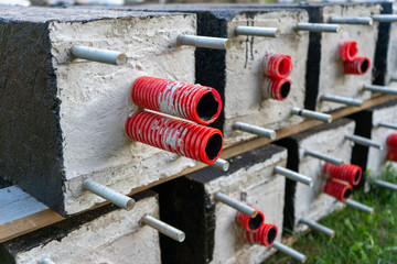 Concrete blocks with a red pipe inside. Laying of communications Corrupted pipes for electrical...
