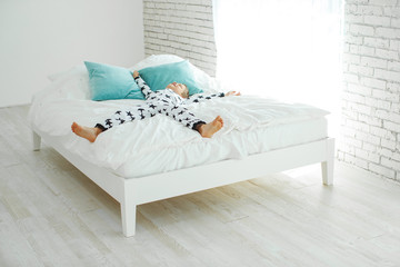 Child on the bed in pajamas. High quality photo.