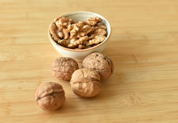 A lot of walnuts with and without shells on the table
