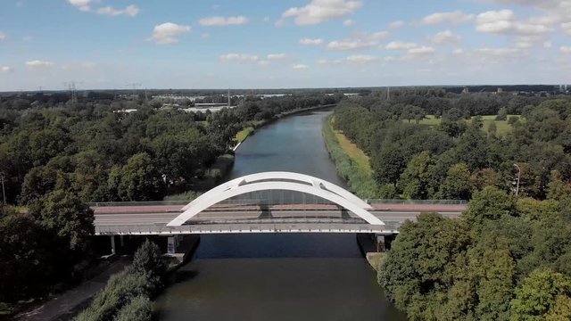 Aerial approach and tilt down showing a steel bridge construction asphalt road over the Twentekanaal in Zutphen, The Netherlands, with cars passing by