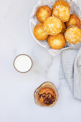 Vanilla muffins and muffins with streusel in paper cups with a glass of milk on light background. Breakfast or snack for children.