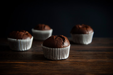 muffin dessert on a wooden surface, on a black background. Side view.