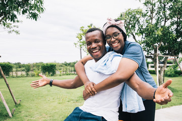 A warm family of black Americans. They are playing activities and bright smile. Concepts of relationship building and leisure activities in the garden. Being the best couple love