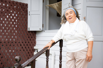 Portrait of elderly woman stand alone at the stairs with hopeless. She lived alone after her retirement and so many times her children would visit. Concepts about learning and stress relaxation