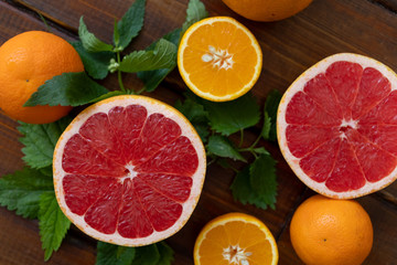 oranges and grapefruit on a brown wooden background, top view, text space, citrus
