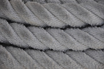 close up of a rope with a knot.Close-up of an old frayed boat rope as background, Spiral of rope, Coiled rope on boats deck
