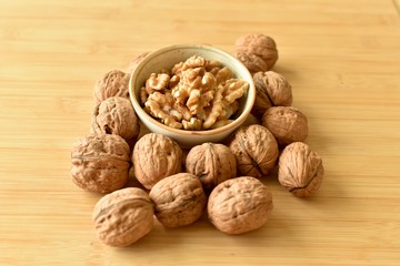 A lot of walnuts with and without shells on the table