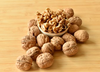 A lot of walnuts with and without shells on the table