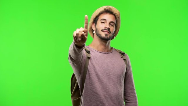Young traveler man on chroma showing number one