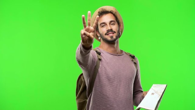 Young traveler man on chroma showing number three