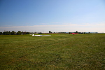 Fototapeta na wymiar View of Glider being towed to take off at green airfield with blue sky in Germany
