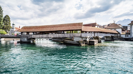 Fototapeta premium Spreuerbrücke in der Stadt Luzern, Historische Brücke aus Holz, im Hintergrund die Jesuitenkirche, im Vordergrund die Reuss, Schweiz