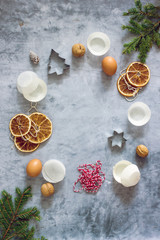 Fototapeta na wymiar Christmas food recipe background. A book for writing recipes on a dark table surrounded by fir branches, dried oranges, paper molds for cupcakes, nuts. Top view, flat lay, copy space