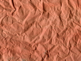 Crumpled textured paper. Red and orange shades. Abstract background.