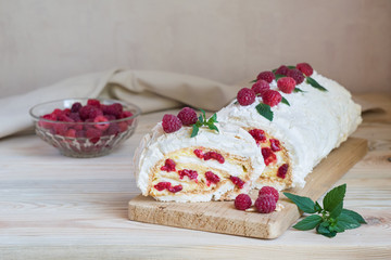 Meringue roulade with cream and raspberries, horizontal orientation, selective focus