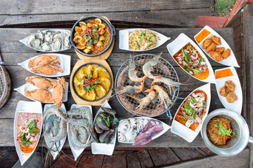 Seafood buffet grill comes in a white plate, looks delicious, delicious, ready to eat, available on a wooden table with a grill.