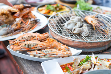 Seafood buffet grill comes in a white plate, looks delicious, delicious, ready to eat, available on a wooden table with a grill.