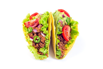 Two taco shells isolated on white, with lettuce, ground beef meat,  mashed avocado, tomato, red onion and jalapeno pepper