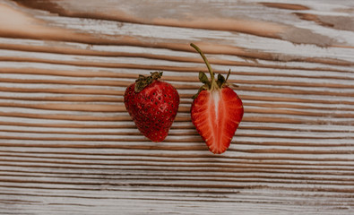 scattered juicy fresh red strawberries on the table with vintage plank. mint leaf. drops and splashes of spilled milk. vegetable cutting board. High quality photo
