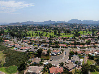 Aerial view of middle class neighborhood with residential house community and mountain on the background in Rancho Bernardo, South California, USA.