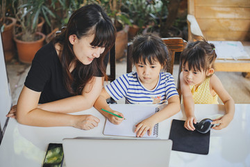 Happy family of mom and preschool daughter using laptop for remote study at home. Mother teach kids to do homework via online classroom. Concept for distance learning education during quarantine time.