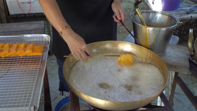 woman making golden egg yolk thread or Foi Thong which is Thai dessert