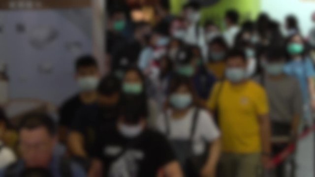 Slow motion blurred defocused view of crowd people wearing surgical mask in escalator of subway. Coronavirus pneumonia has been spreading into many cities. 2019-nCoV epidemic China.-Dan