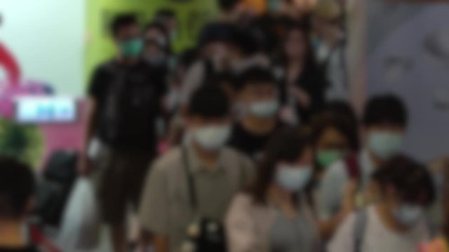 Slow motion blurred defocused view of crowd people wearing surgical mask in subway entrance escalator. Coronavirus pneumonia has been spreading into many cities. 2019-nCoV epidemic of China-Dan