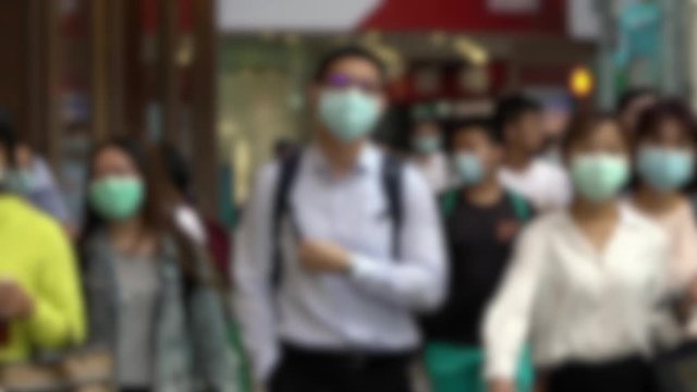 Slow motion of blurred defocused view of people wearing face masks during coronavirus outbreak. Asian pedestrian walking on scramble crossing street using surgical mask against covid19. Unfocused -Dan