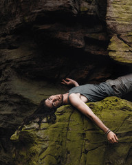 Young man lying casually on a rock while climbing in nature on a mountain