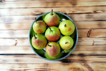 juicy delicious pears in a plate on a wooden background