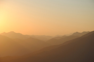 sunset in mountains. peaks and hills against clean sky