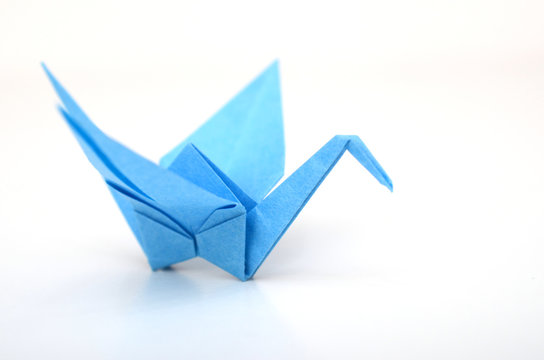 a blue origami bird paper on white
