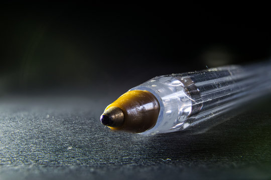 primo piano della punta a sfera di una penna bic, su sfondo nero