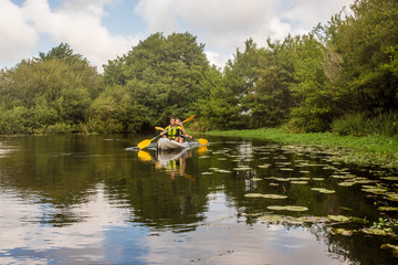 Fototapeta na wymiar young couple kayaking down the river