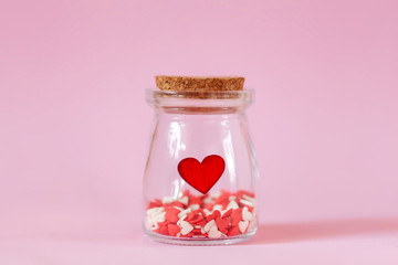 Red hearts in a glass jar. Concept for charity, love, health insuarence, World heart day.