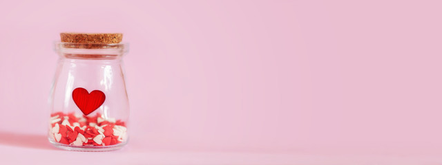 Red hearts in a glass jar. Concept for charity, love, health insuarence, World heart day.