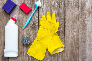 Cleaning and cleaning products. Sponge brushes and bleach on a wooden background. Copy space, top...
