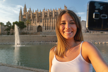 Woman taking selfie in front of cathedral © NDStock