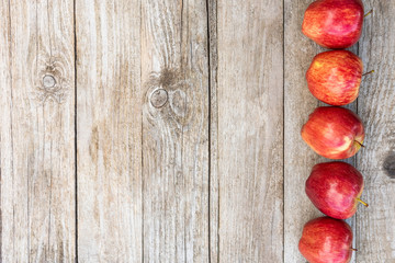 Lots of delicious and juicy apples on a wooden background. Copy space.