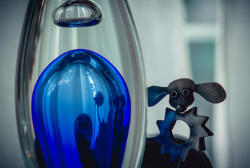 Metal poodle dog and its reflection in a blue glass flask, abstract design © maaramore©	