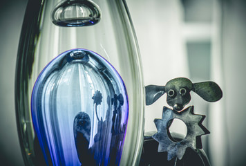 Metal poodle dog and its reflection in a blue glass flask, abstract design © maaramore©	