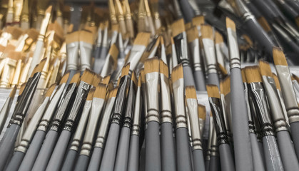 Lots of art brushes on the counter for sale. Showcase with brushes.