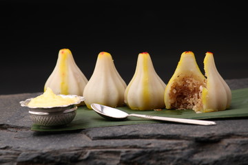 Modak- a traditional dish made on Ganpati festival in India. Served with clarified butter or ghee. Over banana leaf