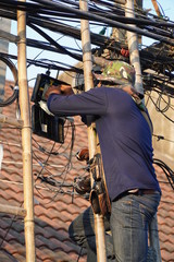 The technician is installing fiber optic for internet network.
