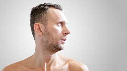 Obraz premium close-up profile portrait of a young white male with a naked torso with copy space