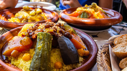Couscous (Arabic: كُسْكُس‎ ) is a Maghrebi dish of small (about 3mm diameter) steamed balls of crushed durum wheat semolina, usually served with a stew spooned,vegetables at family gatherings.