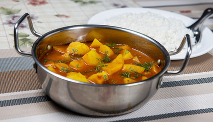 Pot of potato chunks cooked in tomato gravy.