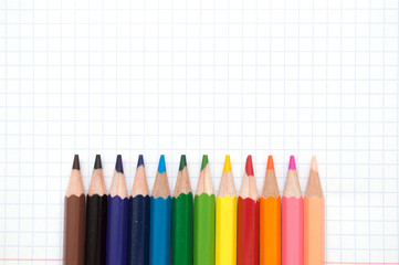 Naklejka premium Colorful pencils Multicolored Pencils on school notebook