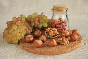 Still life of walnuts, hazelnuts, kishmish grapes. Healthy snack. HLS.